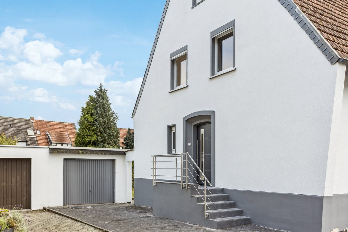 Sanierte weiße Fassade des Einfamilienhauses Im Hessle nach der Modernisierung
